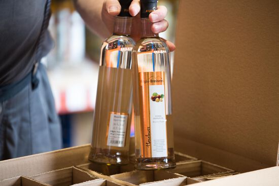 zwei Flaschen Haselnuss-Schnaps werden in einen Karton gepackt.