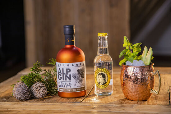 Neben der Flasche AlpGin Zirbe finden Zirbelkieferzapfen Platz sowie eine Flasche Thomas Henry Tonic Water.